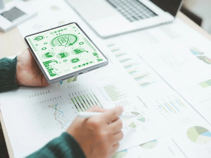 Personne consultant des graphiques et des rapports de durabilité avec un smartphone posé sur la table