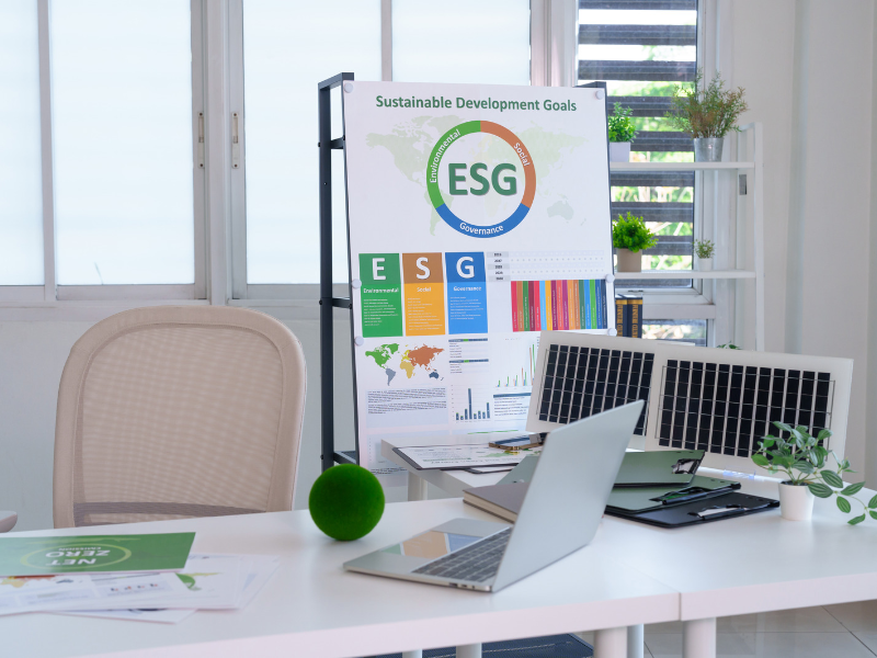 Bureau lumineux avec ordinateur portable et panneau « Sustainable Development Goals » présentant des indicateurs ESG